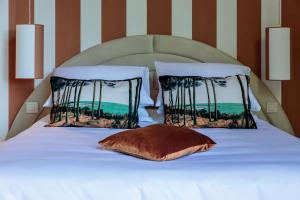 a white bed with two pillows on top of it at La Villa Kara in Romans-sur-Isère
