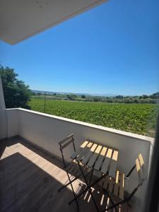 un balcone con una panchina e vista su un campo di Pubble beach apartment a Fossacesia