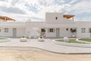 a white villa with a courtyard in front of it at Ariadne's Crown Luxury AstroConcept Suites with Private Pools and Spas in Vívlos