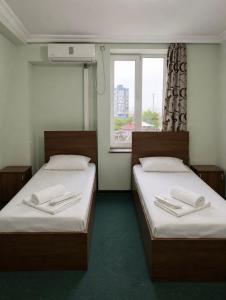 two beds in a small room with a window at Renesans Hotel Kobuleti in Kobuleti