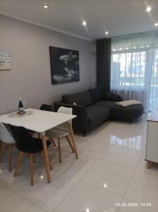 a living room with a table and a couch at Blue Mare Hebe Apartament in Łukęcin