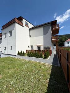 a white house with a fence and a yard at Apartmán Mnichov in Vrbno pod Pradědem