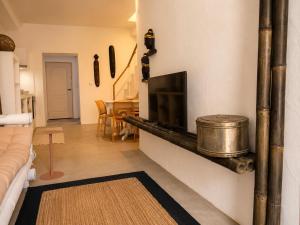 a living room with a tv on a wall at Pátio 38 do frade in Aldeia do Mato