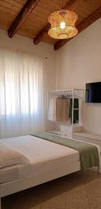 a bedroom with a bed and a chandelier at Terrazza Ganzaria in San Michele di Ganzaria