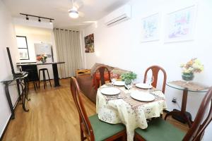 a dining room and living room with a table and chairs at Confortável 1 Quarto Ar Wi-fi Garagem in Vitória