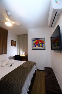 a hotel room with a bed and a tv at Confortável 1 Quarto Ar Wi-fi Garagem in Vitória