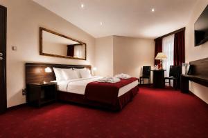 a hotel room with a bed and a mirror at Hotel Centrum Sosnowiec in Sosnowiec