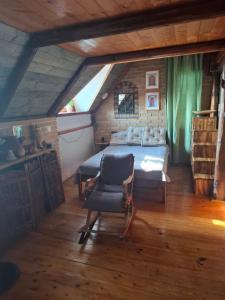 a bedroom with a bed and a chair in a attic at Agroturystyka Kalina Wielka in Kalina Wielka