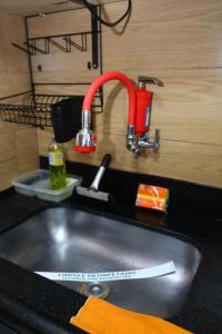 a kitchen sink with a red faucet over it at Confortável 1 Quarto Ar Wi-fi Garagem in Vitória +54 photos