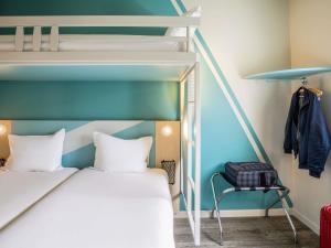 a bedroom with a bunk bed and a chair at ibis budget Haguenau Strasbourg Nord in Haguenau