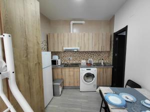 a small kitchen with a washing machine and a table at Rua de Galicia 1 in Ribeira