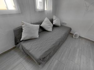 a couch in a living room with pillows on it at Rua de Galicia 1 in Ribeira