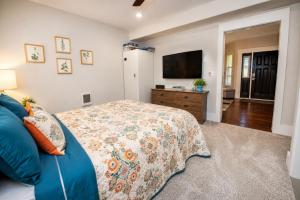 a bedroom with a blue bed and a flat screen tv at Seaside Saloon Hot Tub Getaway in Sequim
