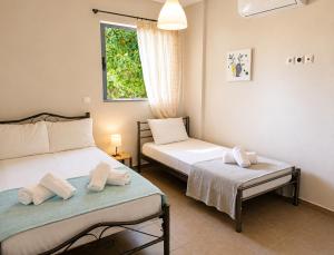 a bedroom with two beds and a window at House In The Garden in Preveza
