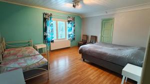 a bedroom with two beds and a wooden floor at Inka's Guesthouse in Alavus