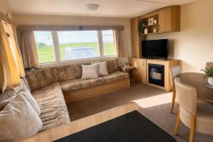 a living room with a couch and a large window at 7 Jay Valley in Bridlington