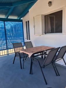 a table and chairs on a patio with a window at La casa di lefki in Elafonisos