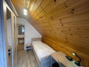 ein kleines Zimmer mit einem Bett und einer Holzwand in der Unterkunft Mariennest in Jever