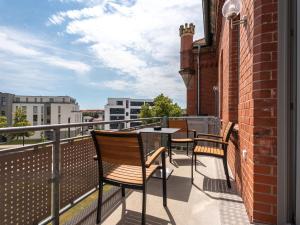 a balcony with two chairs and a table on a building at "Sonnenstübchen" Apartment mit eigenem Parkplatz und WiFi in Magdeburg