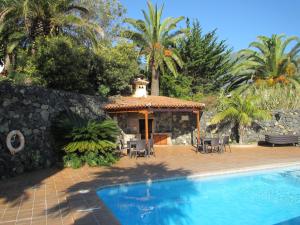 ein Haus mit einem Pool und einem Pavillon in der Unterkunft Casas-Bungalows Los Pajeros in Breña Baja