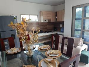 a kitchen with a dining table with plates and flowers at Hotel Kelly Mar in Tolú