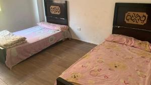 two beds are in a room with at Soukaina home in Sintrīs