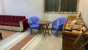 a living room with three blue chairs and a table at Soukaina home in Sintrīs