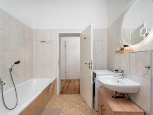 a bathroom with a tub and a sink and a bath tub at "Sonnenstübchen" Apartment mit eigenem Parkplatz und WiFi in Magdeburg +6 photos