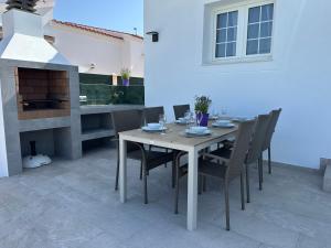 a dining room table and chairs with a fireplace at Villa Vistamar - Piscina privada, vistas al mar y a 5 min de la playa in Cala en Porter