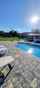 a swimming pool with a bench next to a house at Mazurskie Wzgórze Dom Wakacyjny in Rydzewo