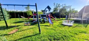 a playground with a slide in the grass at Mazurskie Wzgórze Dom Wakacyjny in Rydzewo