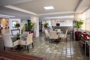 a restaurant with tables and chairs and a counter at Petrolina Palace Hotel in Petrolina