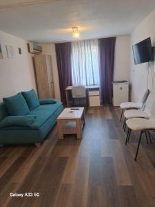 a living room with a blue couch and chairs at Strada Banu Mihalcea Nr. 150 in Constanţa
