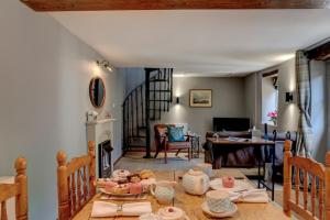 a living room with a table and a fireplace at The Cotswolds Hidden Gem in Moreton in Marsh