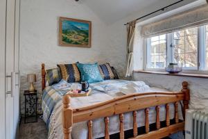 a bedroom with a wooden bed and a window at The Cotswolds Hidden Gem in Moreton in Marsh