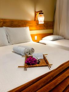 a hotel room with a tray of flowers on a bed at Pousada Do Porto in Barreirinhas