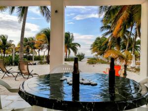 a table with two bottles of beer on the beach at Cozy beachfront house Cocomar in San Crisanto