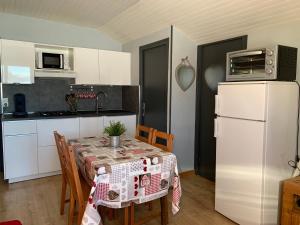 a kitchen with a table and a white refrigerator at Chalet Les Jouves in Prémanon