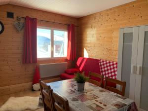 a dining room with a table and a red chair at Chalet Les Jouves in Prémanon