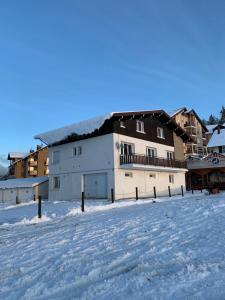 a large white building in the snow with buildings at Chalet Les Jouves in Prémanon