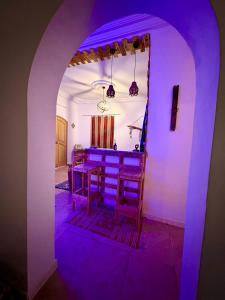 an archway with purple lights in a room at Dar Chahla in Tozeur