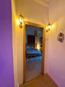 a hallway with a mirror and a room with a bed at Dar Chahla in Tozeur +9 photos