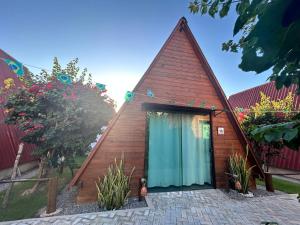 a small wooden house with a blue door at Pousada Villa Al Mare in Luis Correia