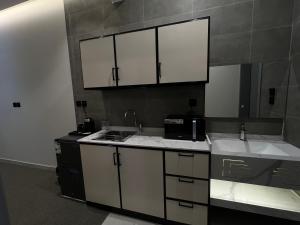 a kitchen with white cabinets and a sink at شقق فاخرة in Mahlal +20 photos