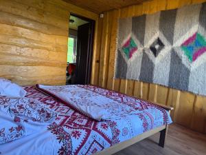 a bedroom with a bed in a wooden cabin at Погарь Квасівський in Kvasy