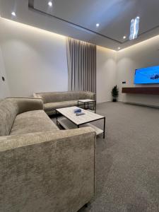 a living room with a couch and a flat screen tv at شقق فاخرة in Mahlal