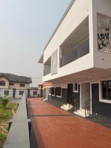 a building with a red walkway in front of it at Oak Serviced Apartment-New Bodija in Ibadan
