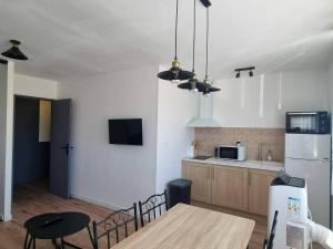 a kitchen with a table and a refrigerator at Palma 2 in Port-la-Nouvelle