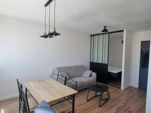 a living room with a table and a couch at Palma 2 in Port-la-Nouvelle +2 photos