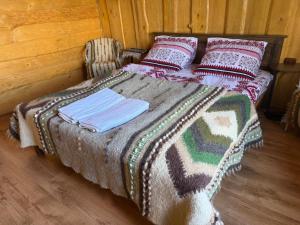 a bed with a blanket and pillows on it at Погарь Квасівський in Kvasy